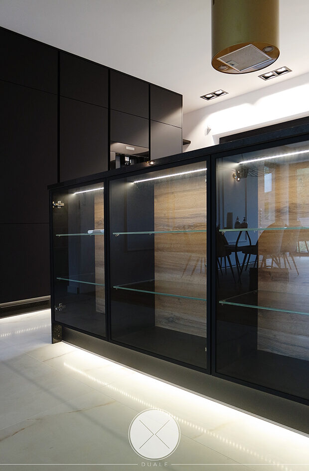 Projekt kuchni czarnej z drewnianym blatem i witrynami