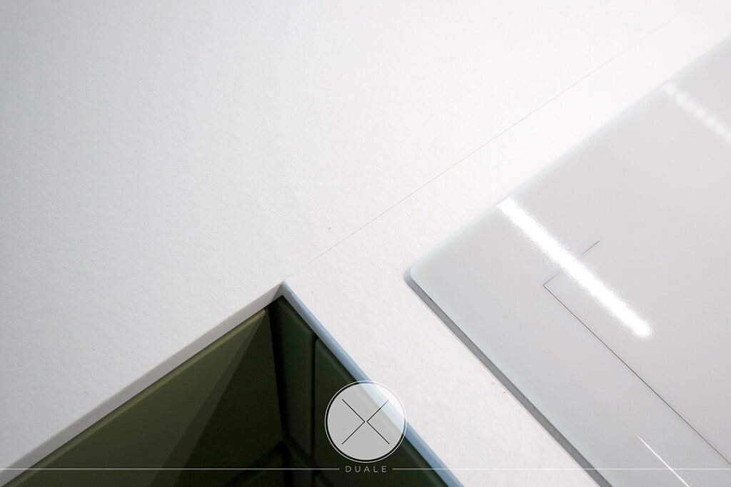 Projekt kuchni oliwkowej z białym blatem i czarnymi szafkami górnymi