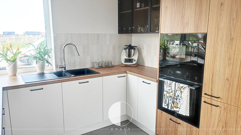 Kuchnia na wymiar biała z drewnianym blatem i słupkami